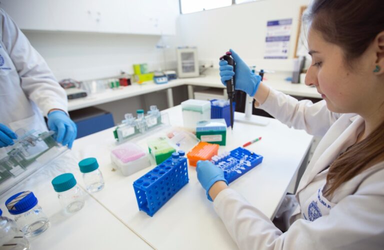 Mujer en un laboratorio científico utilizando una micropipeta.